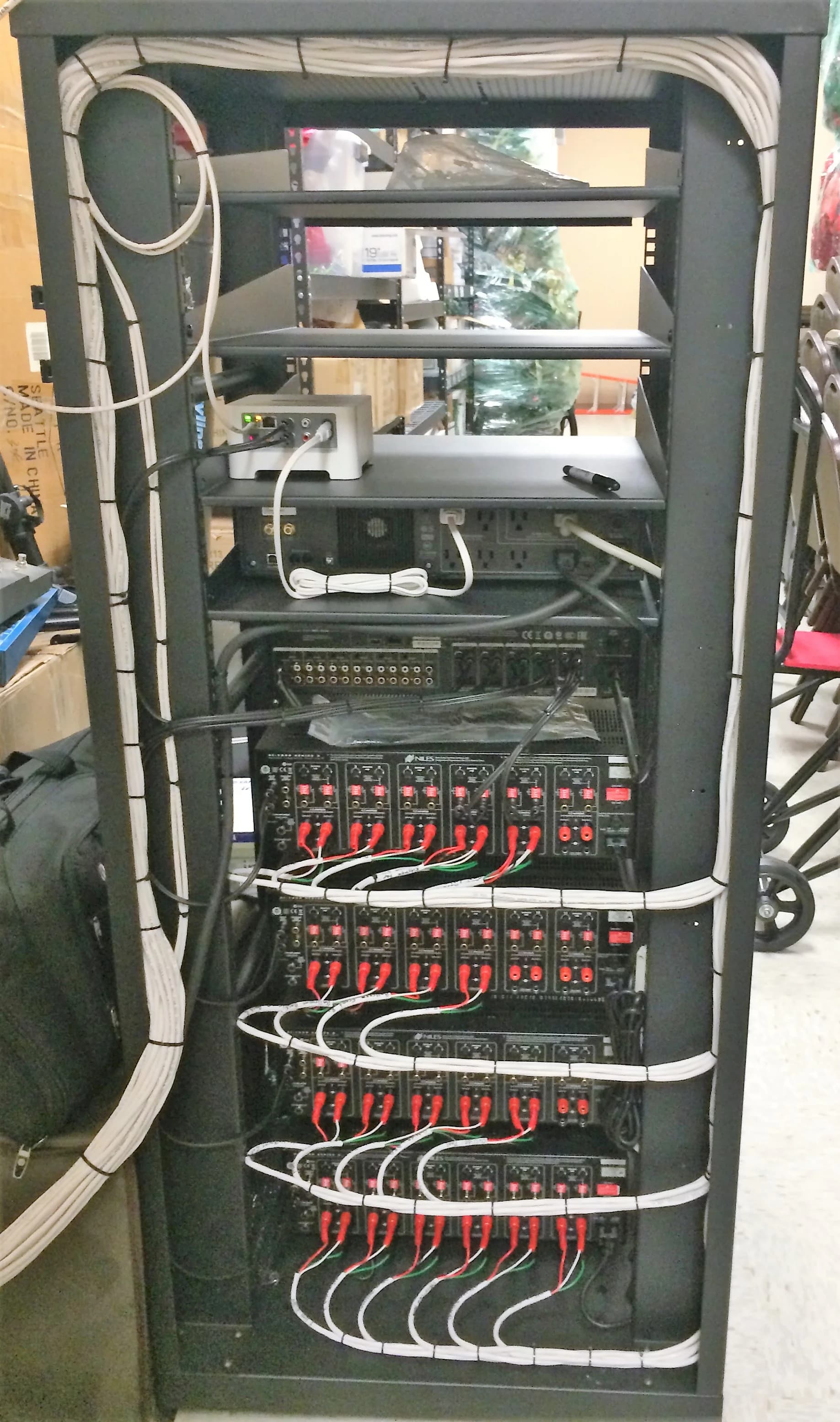 Rear of a multi-channel amplifier bank with dressed speaker runs
